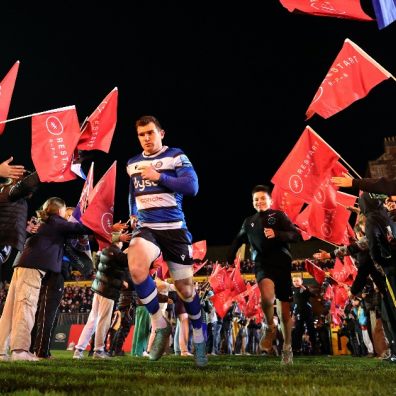 Rugby players running out onto rugby pitch