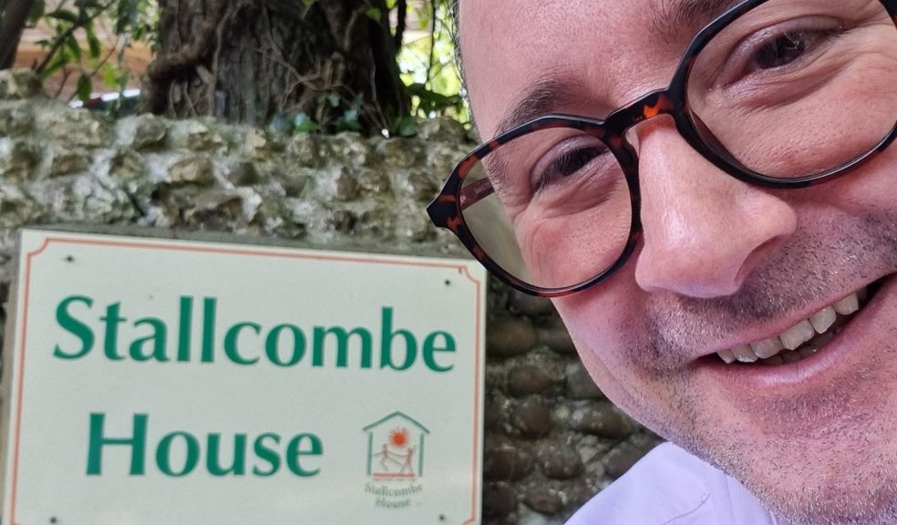 Man in front of sign for Stallcombe House